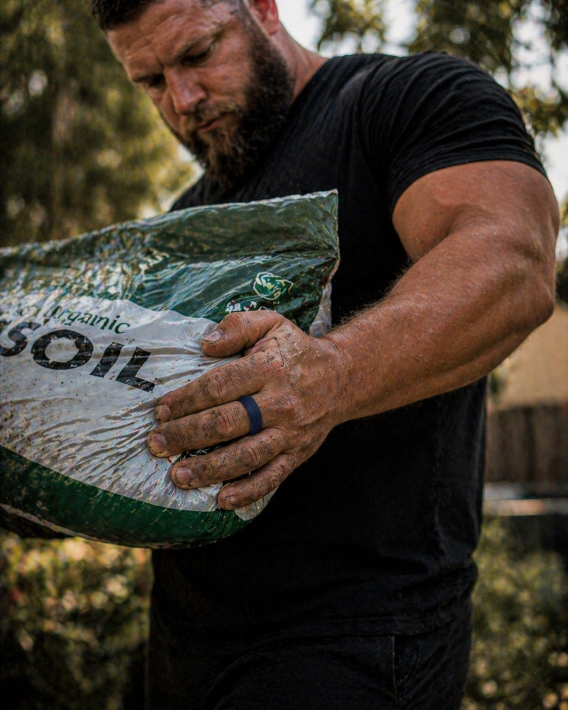 Dura Gear blue silicone ring worn while carrying soil bag outdoors, durable flexible ring for work and everyday use