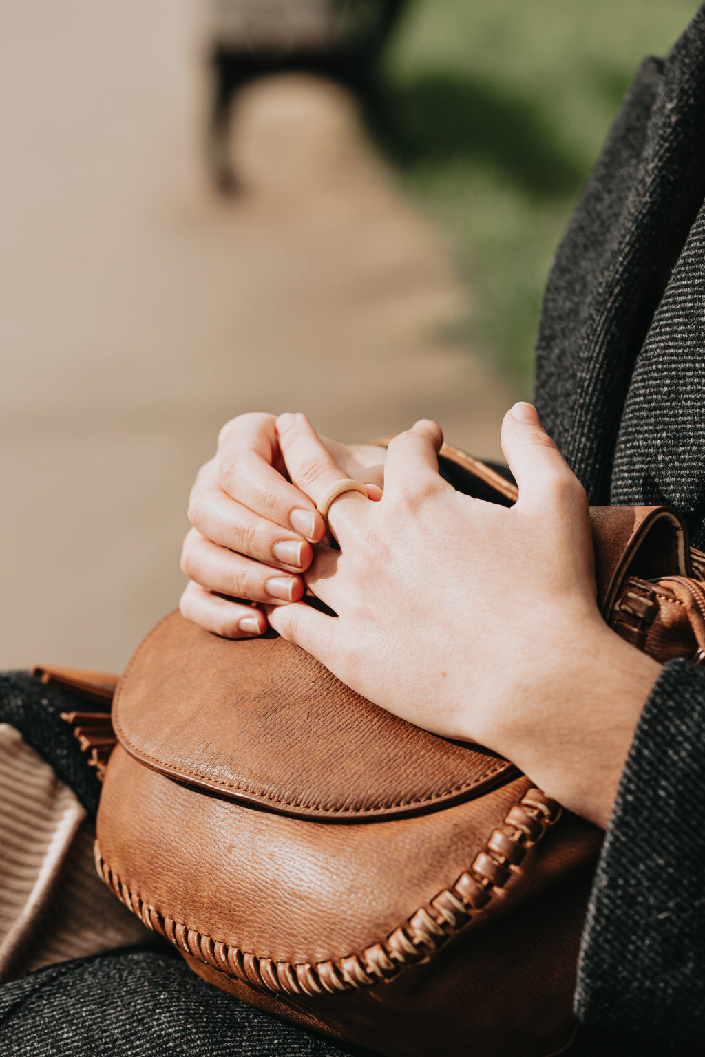 Woman wearing Maple silicone ring during everyday use holding a leather bag